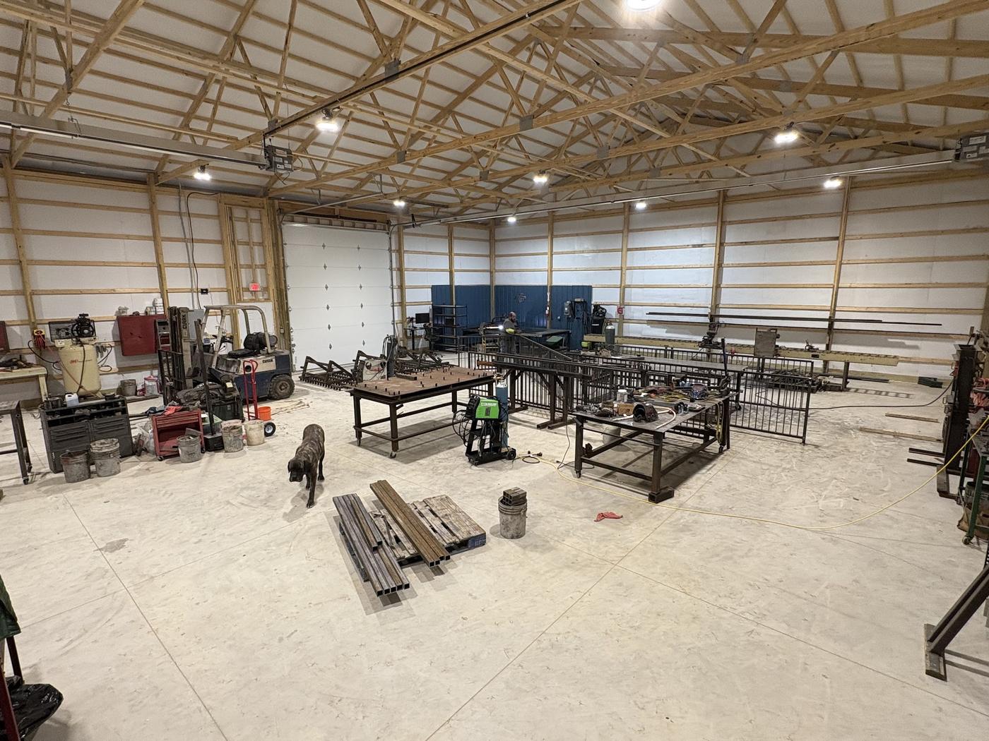 Ornamental iron railing panels part-fabricated on benches inside the workshop